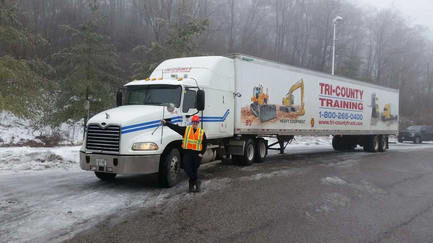 Alex during his early trucking career in Canada beside a transport truck